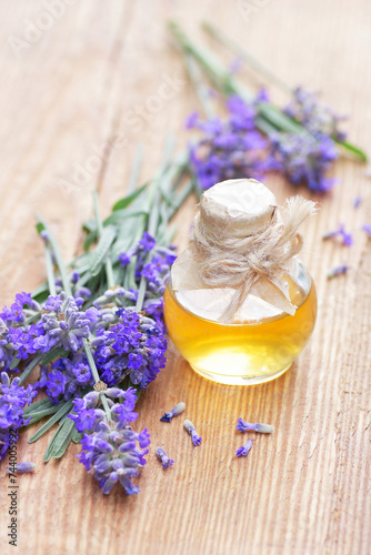 Lavender oil or extract on wooden background with fresh flowers nearby, copy space, natural medicine, herbal remedy for insomnia and stress, natural hair and skin treatment, aromatherapy concept