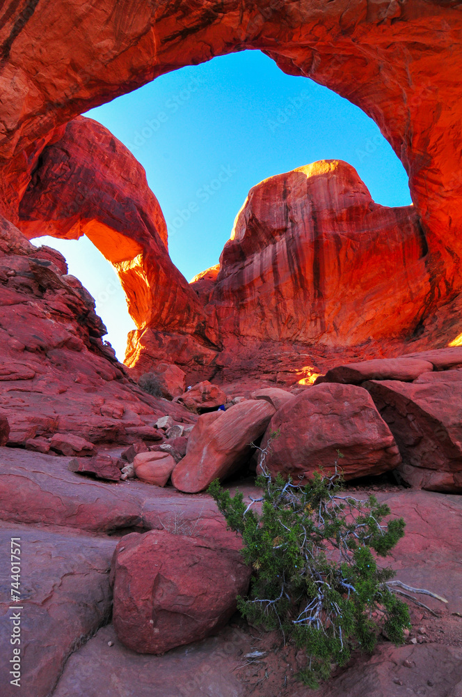 Hikers on the Double Arch at sunset, Arches National Park, Moab, Utah, Southwest USA.