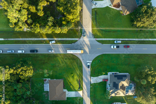 Top view of classical american yellow school bus driving on rural town street for picking up kids for their lessongs in early morning. Public transport in the USA photo