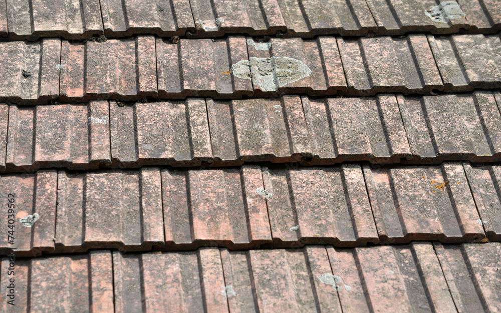 On the roof of the house is an old red tile