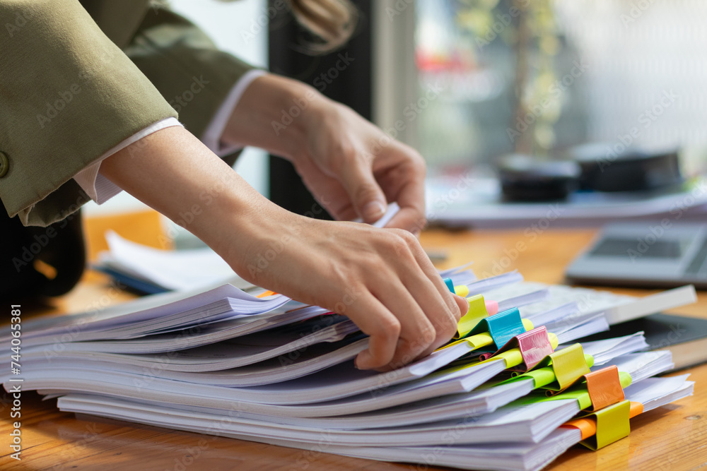 secretary is searching through pile of important documents on office table deliver them to manager for presentation in time at meeting. Concept of difficulty finding information from piles of document secretary is searching through pile of important documents on office table deliver them to manager for presentation in time at meeting. Concept of difficulty finding information from piles of document
