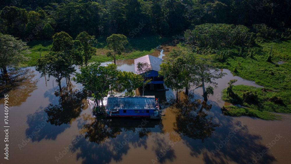 Aerial view of a flooded area (igapó) and houses on stilts, based on the traditional knowledge and venacular architecture of the Brazilian Amazon, in the community of Xiborena near Manaus (AM) Aerial view of a flooded area (igapó) and houses on stilts, based on the traditional knowledge and venacular architecture of the Brazilian Amazon, in the community of Xiborena near Manaus (AM)
