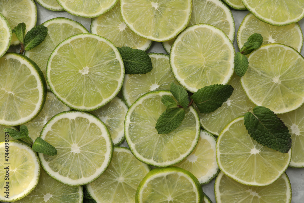 Slices of fresh juicy limes as background, top view