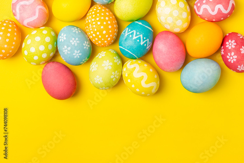 Easter eggs on a bright yellow background. Easter celebration concept. Colorful easter handmade decorated Easter eggs. Place for text. Copy space.