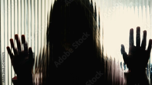 Little Girl's Silhouette Showing Sadness on Glass, Concept of Childhood Mental Health Struggles, somber moody contrast