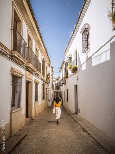 A beautiful young woman dressed elegantly walking through the San Basilio neighborhood in the historical old town of Cordoba, Andalusia, Spain photo