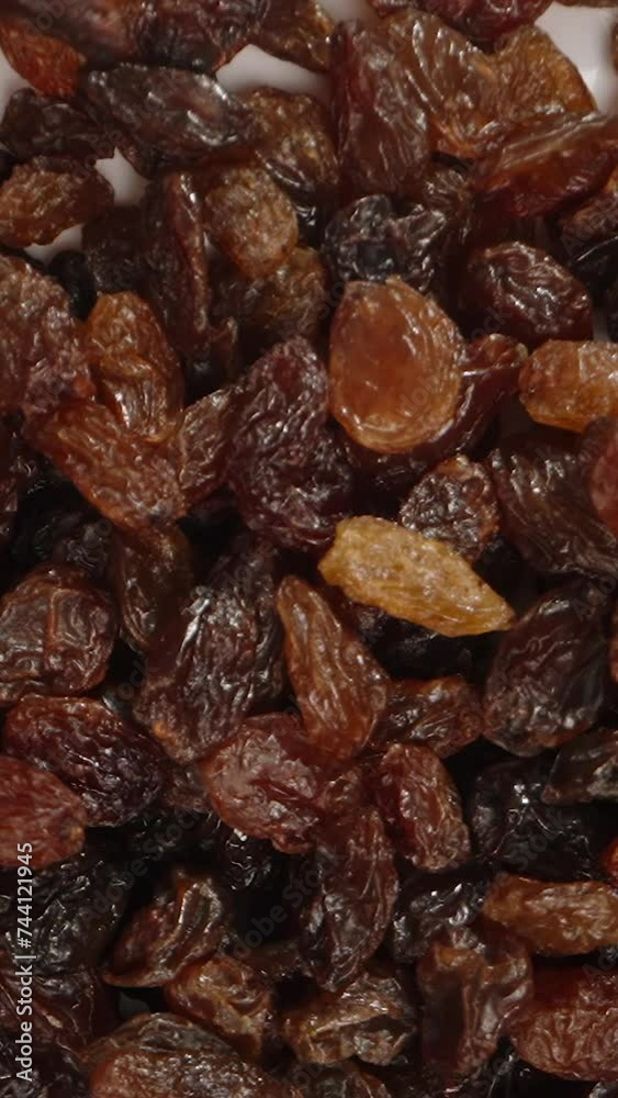 Vertical video. Raisins fall down, top view, in slow motion. Vertical video. Raisins fall down, top view, in slow motion.