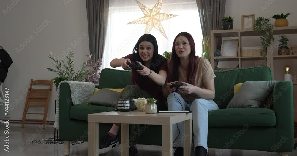 Two young women caucasian friends or sisters play console video game Two young women caucasian friends or sisters play console video game
