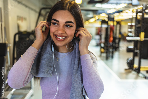 Shot of a sporty young woman listening to music while exercising in a gym.