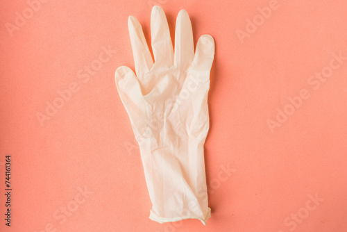 White medical glove on pastel pink background. Minimal concept or element of pattern