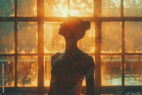 A ballet dancer practicing alone in a sunlit studio, their silhouette a study in grace and dedication.