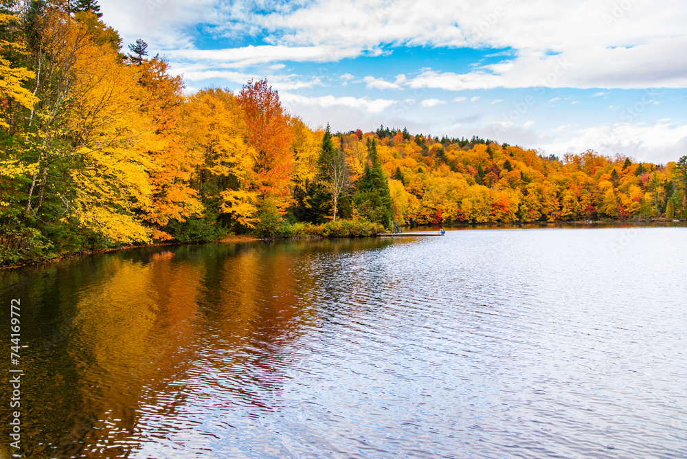 Lac-du-missionaire, Canada: Oct.10 2022: Morning fog on the lake of Lac-du-missionaire with colorful leaves in Quebec in a sunny autumn day Lac-du-missionaire, Canada: Oct.10 2022: Morning fog on the lake of Lac-du-missionaire with colorful leaves in Quebec in a sunny autumn day