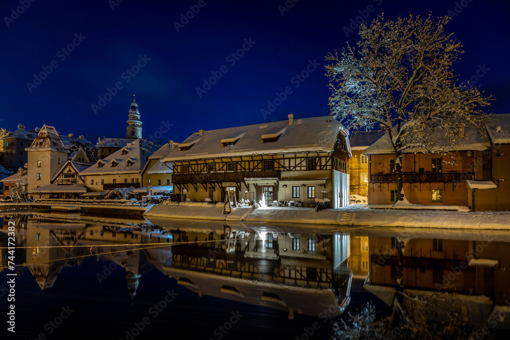 Winter view of Cesky Krumlov, picturesque houses under the castle with snow-covered roofs. Narrow streets and the Vltava river. Travel and Holiday. Christmas time. UNESCO World Heritage. Czechia