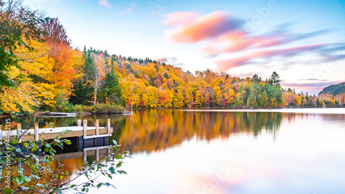 Fototapeta Naklejka Na Ścianę i Meble -  Lac-du-missionaire, Canada: Oct.10 2022: Morning fog on the lake of Lac-du-missionaire with colorful leaves in Quebec in a sunny autumn day