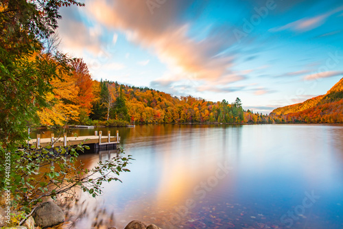 Fototapeta Naklejka Na Ścianę i Meble -  Lac-du-missionaire, Canada: Oct.10 2022: Morning fog on the lake of Lac-du-missionaire with colorful leaves in Quebec in a sunny autumn day
