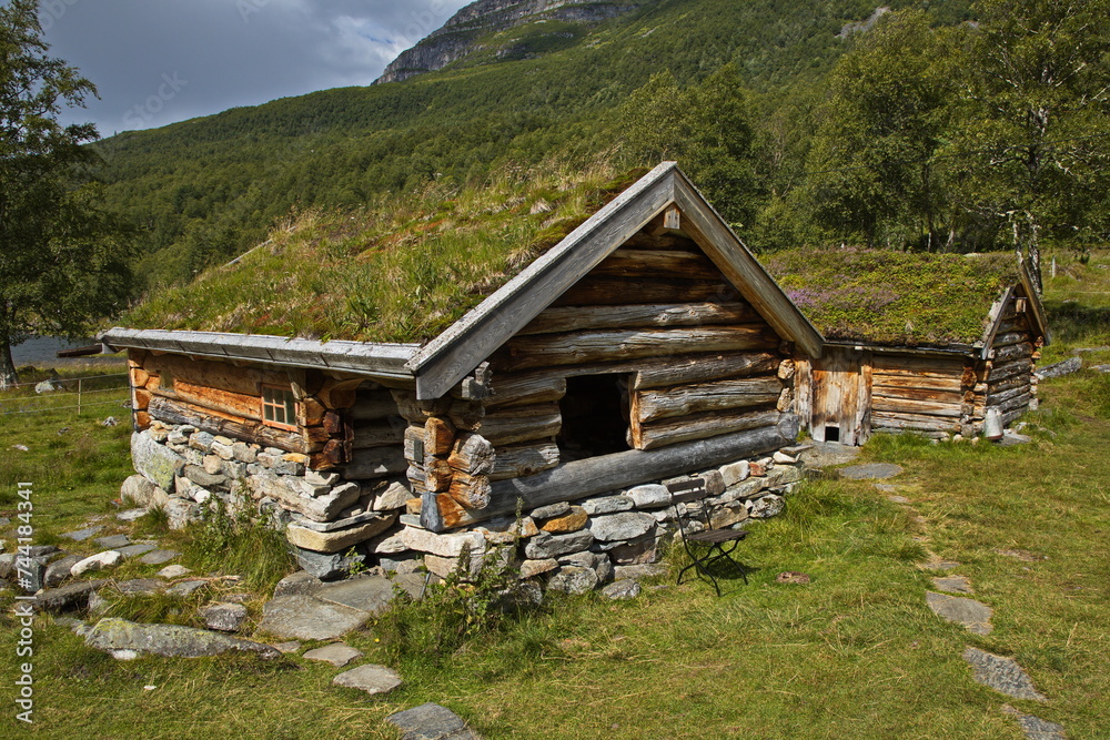 Old wooden cottage with green roof in Innerdalen valley, Norway, Europe
