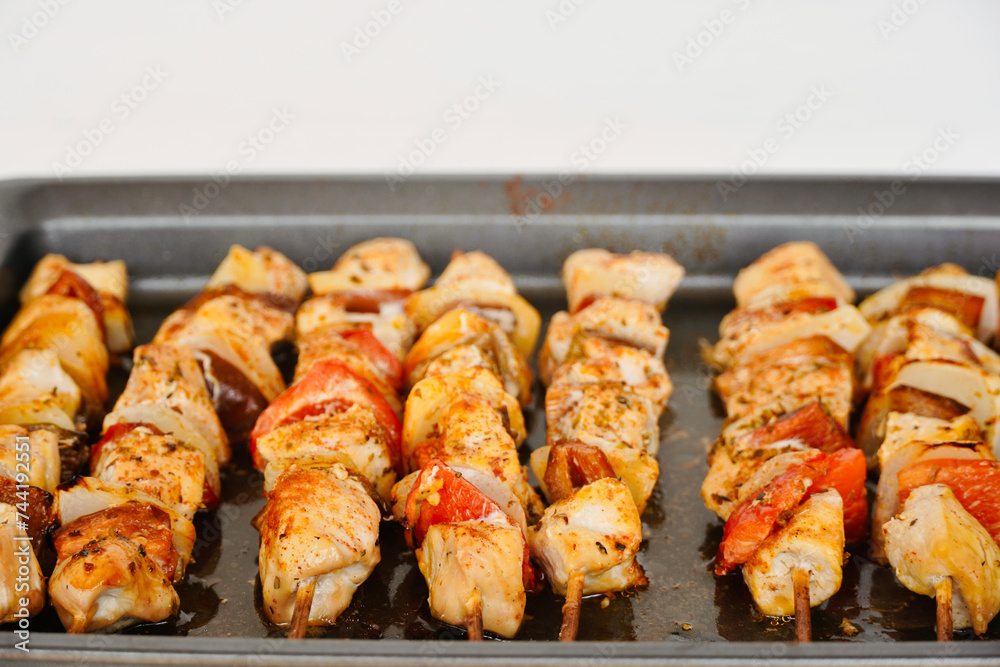Close-up chicken skewers with vegetables in the oven with copy space.