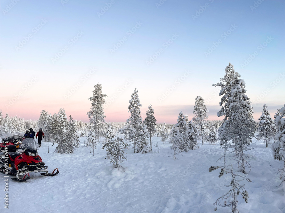 Snow motorbike parked on a white snowy forest landscape in Finnish Lapland