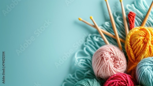 Knitting yarn balls and needles on a blue surface photo