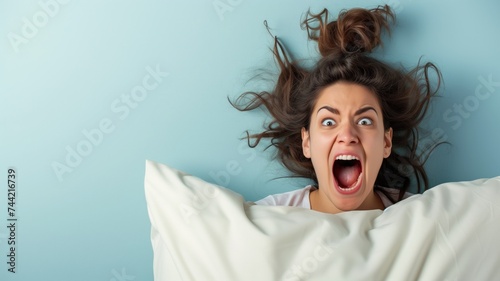 Woman in bed screaming, shocked by alarm
