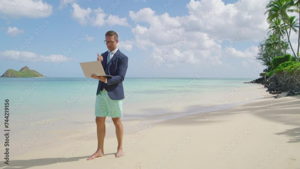 Confident caucasian man in suit and beach shorts holding open laptop in hands, standing barefoot on warm sand of the Hawaiian island over azure ocean. High quality 4k footage Confident caucasian man in suit and beach shorts holding open laptop in hands, standing barefoot on warm sand of the Hawaiian island over azure ocean. High quality 4k footage