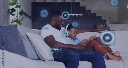 Image of diverse data over happy african american father and son using tablet