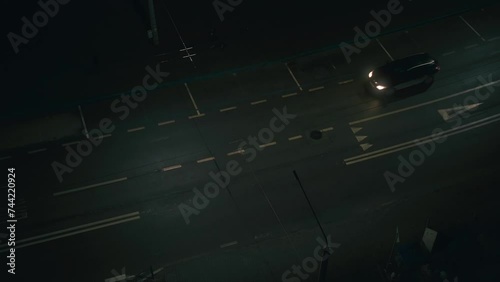 City street night shot. Empty road in the town top view. Single car on the way