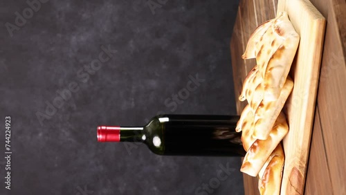 Chilean wine glasses and bottle and empanadas variety. Chile Food background. Fresh ingredients on wood. Selective Focus, vertical video. photo
