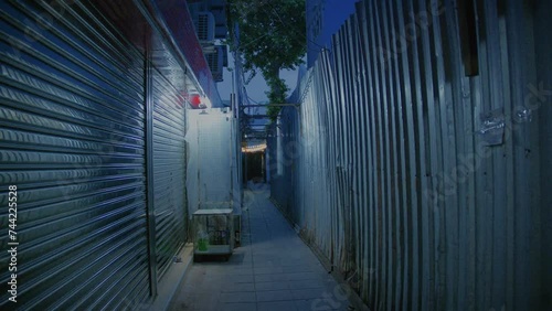 Closed shop narrow metallic alleyway at night in Bangkok photo