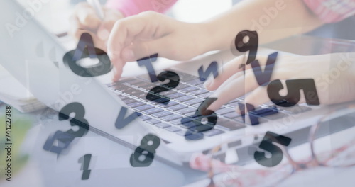 Image of words and numbers changing over woman using laptop