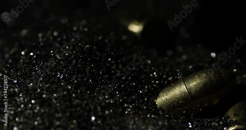 9×19mm Parabellum bullets macro detail closeup shot fall on gunpowder, slowmo photo