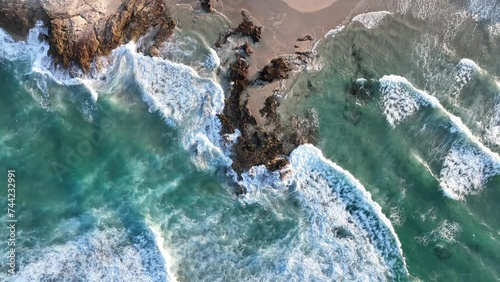 Top down static shot of Stradbroke Islands Rocky Coast Line. Waves hitting the rocks on beach, Golden Hour Shot of Waves Crashing into Rocks in slow motion Drone shot. 4K QLD Australia Tourism photo