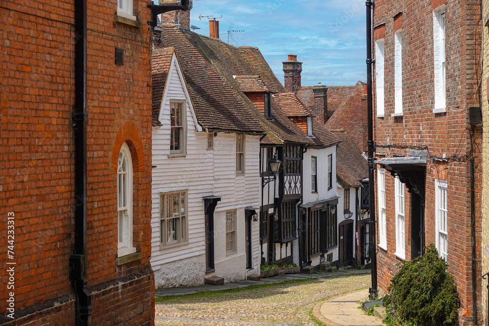 Summer walk along a charming street with brick and wooden medieval townhouses