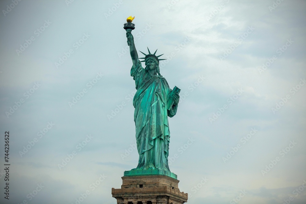 Fototapeta premium Iconic Statue of Liberty standing against a cloudy sky