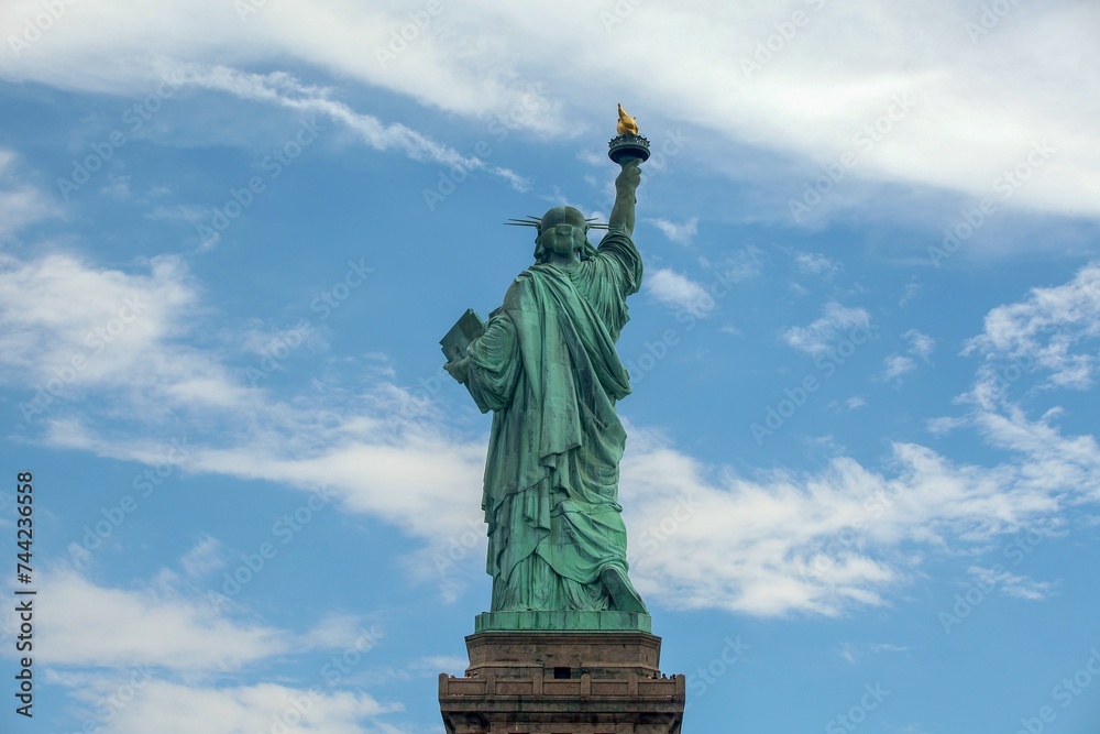 Rear view of the Statue of Liberty standing against a bright, blue sky
