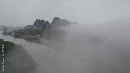 Aerial Shot Through Foggy Clouds Over Ao Phang Na National Park HQ with Views of Mangroves and Limestone Cliffs. photo