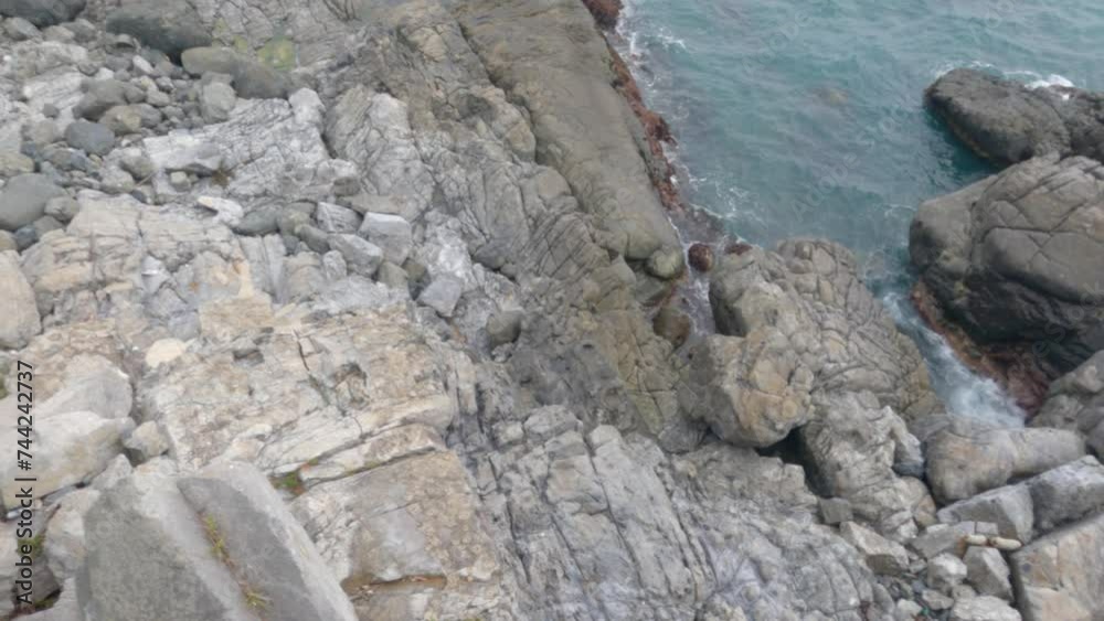 A smooth moving camera shot of rocky cliffside shoreline ocean waves and green pine trees next to the Sea of Japan in coastal Busan, South Korea. A smooth moving camera shot of rocky cliffside shoreline ocean waves and green pine trees next to the Sea of Japan in coastal Busan, South Korea.