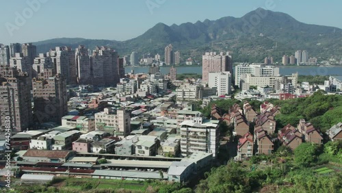 Bright daytime view of Zhuwei, Tamsui district with Taipei mountains in the background, Establishing Shot photo