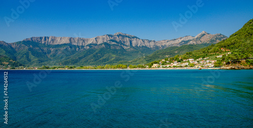 Clear day showcases a beautiful beach with mountains in Thassos, Greece