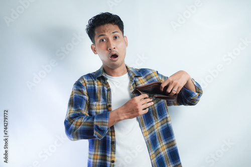 Adult Asian man showing his empty wallet with worried expression