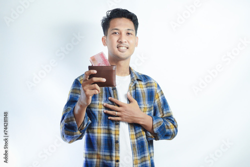 Adult Asian man smiling happy while showing his wallet full of paper money photo