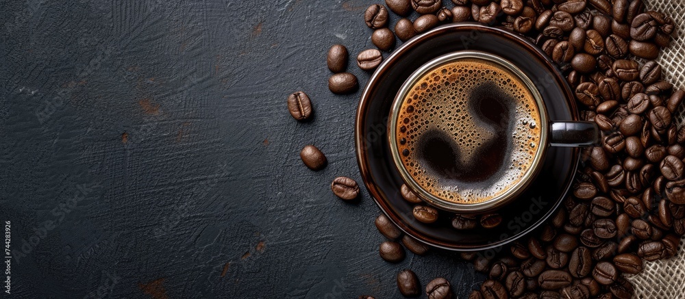 A bold and beautiful cup of black coffee sits on a rustic black background, elegantly blending with the surrounding coffee beans. A bold and beautiful cup of black coffee sits on a rustic black background, elegantly blending with the surrounding coffee beans.
