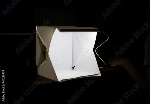 box for product photography illuminating in the middle of the darkness