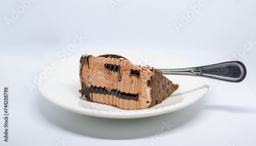 a piece of cake with chocolate and cream whit foek on a white plate