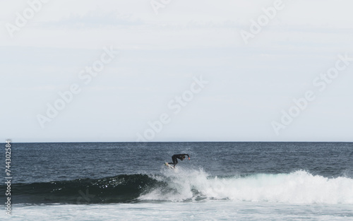 Young surfer doing an aerial turn on a small surfboard 