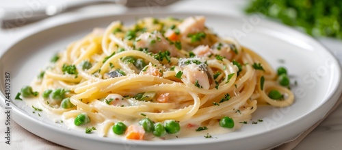 Delicious plate of pasta with fresh peas and succulent shrimp on a white plate
