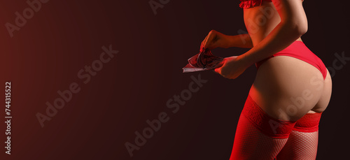 Young prostitute counting money on dark background with space for text photo
