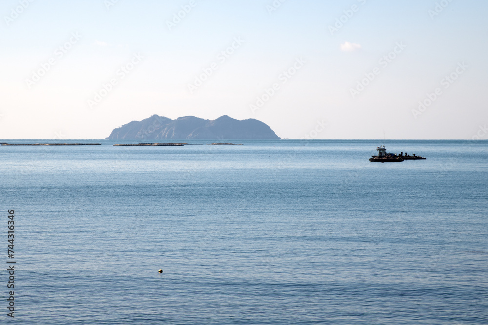Seascape with an island and a fishing boat Seascape with an island and a fishing boat