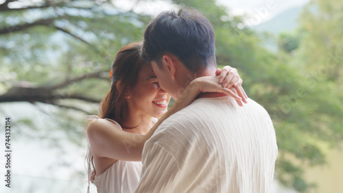 Sweet lovers arm around shoulder hug neck face to face talking at outdoor nature. Trust true love smile happy asia people in casual bride groom white dress begin family life just married young couples photo
