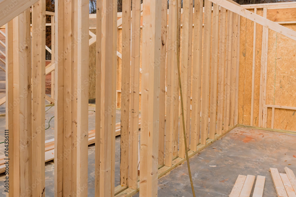 Construction of new home involves use of stick beams, wood, framing Construction of new home involves use of stick beams, wood, framing